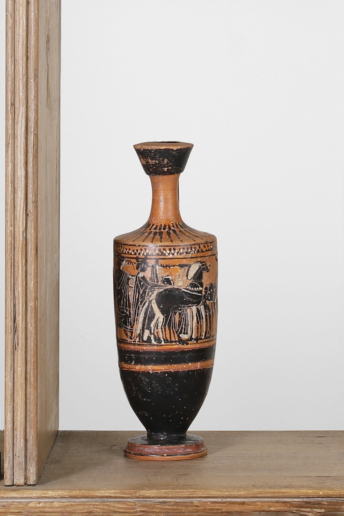 An Attic black-figured lekythos in the manner of the Haimon painter, early 5th century BC, Greek, decorated with figures in a chariot and horses, 6.5cm wide 20cm high